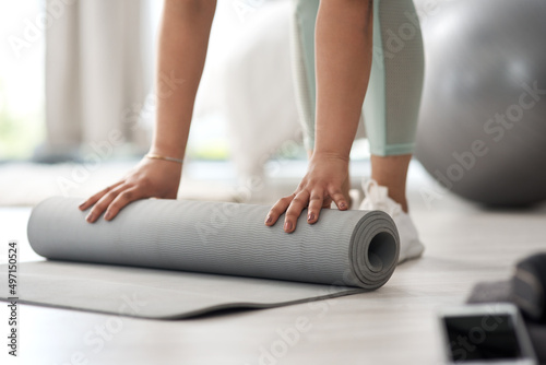 Make a start and youll see the change. Closeup shot of an unrecognisable woman rolling an exercise mat on the floor at home.