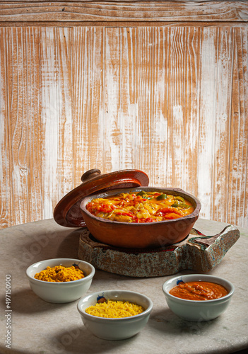 Grouper moqueca served with saffron rice, farofa and pirão and pepper sauce. Typical Brazilian food photo