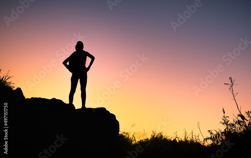 silhouette of woman standing on a hill top looking out at the view 