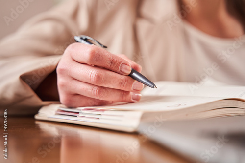 Woman therapist making notes while working at her home office