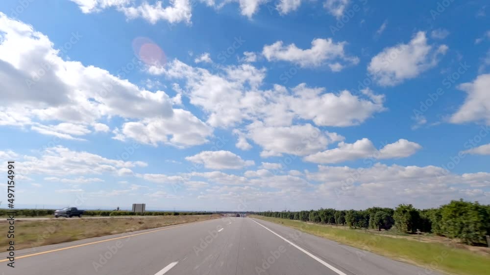 Driving along a country road by an orchard on a picturesque day Driving along a country road by an orchard on a picturesque day
