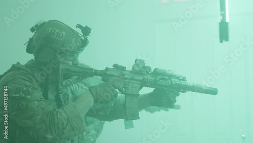 Men walking down corridor lit by flashes. Side view of people in camouflage uniform with rifles playing airsoft military game in building, searching for enemy. Airsoft game, indoor activity concept
