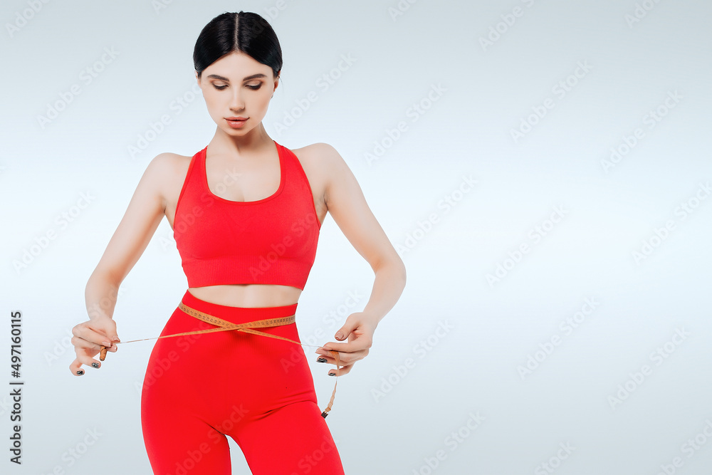 Concept of healthy eating. Fitness woman measuring waist