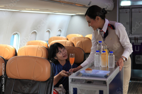 Obraz na płótnie Cabin crew pushing service cart and serve to customer on the airplane during flight. hostess service on plane w salonie