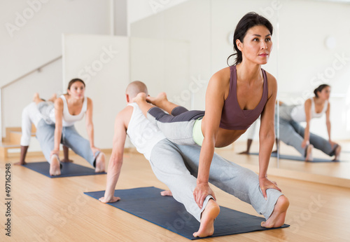 Scene of a group of people practicing couples yoga in class