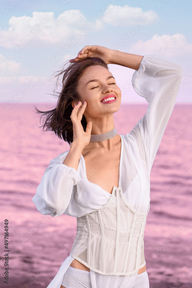 Stylish young woman posing near pink lake on summer day Stylish young woman posing near pink lake on summer day