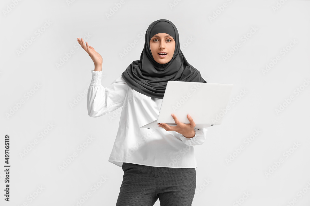 Muslim secretary with laptop on light background Muslim secretary with laptop on light background