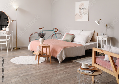 Interior of bedroom with comfortable bed and bicycle