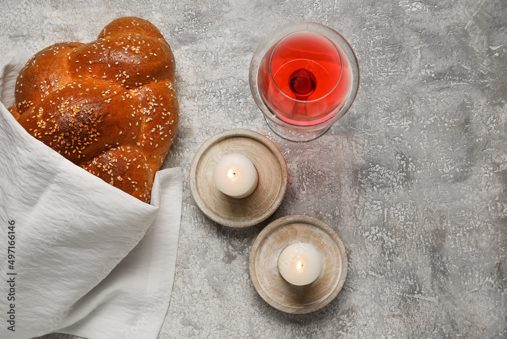 Traditional challah bread with glass of wine and candles on grunge background. Shabbat Shalom Traditional challah bread with glass of wine and candles on grunge background. Shabbat Shalom