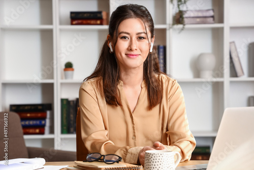 Young Asian tutor in earpho...