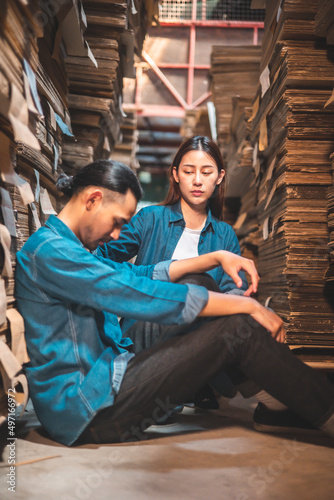 Asian Business owner sitting in factory plantation posing feel tried and serious with work.Engineer or Factory worker hard work.Unemployed Feeling Stressed.