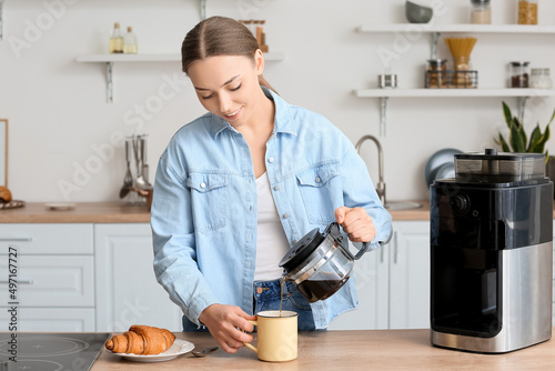 Young woman pouring hot cof...