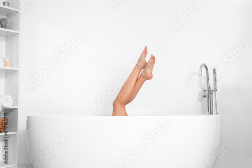 Barefoot woman in bathtub n...