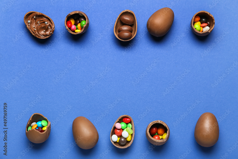 Delicious chocolate eggs with different fillings on blue background