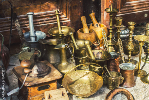  Old stuff and antique utensils on the flea market in ancient town Kruja, Albania. Coffee mill, Turkish cezvas and old bronze bowls for sale.