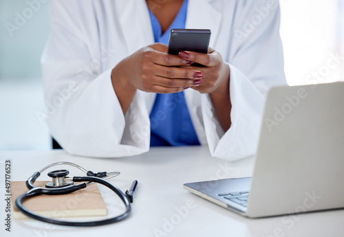 Technology makes my work so much easier. Shot of an unrecognizable doctor using a phone and laptop at work.