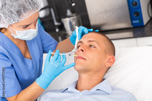 Portrait of man getting face skin rejuvenation treatments at beautician office