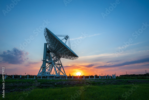 Fotografie Astronomical radio telescope and beautiful sky clouds at sunset