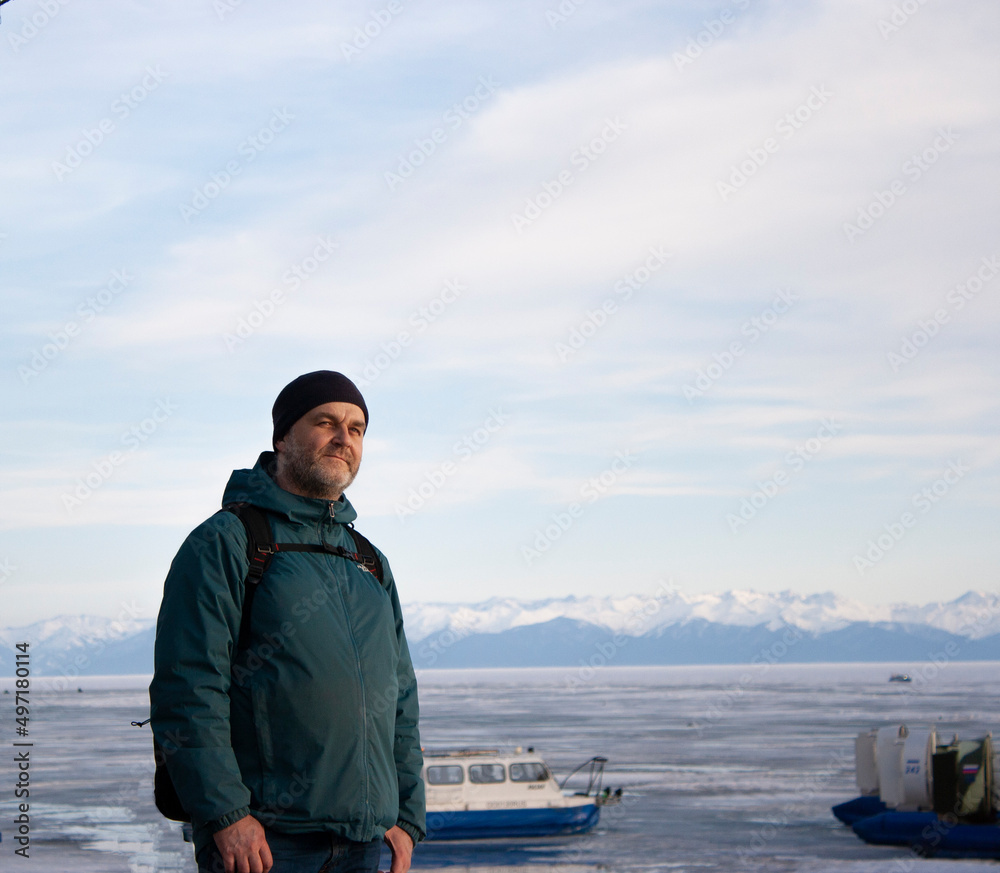 Portrait of a man in winter clothes against the background of the frozen Lake Baikal. Mountains. Hovercraft. Portrait of a man in winter clothes against the background of the frozen Lake Baikal. Mountains. Hovercraft.