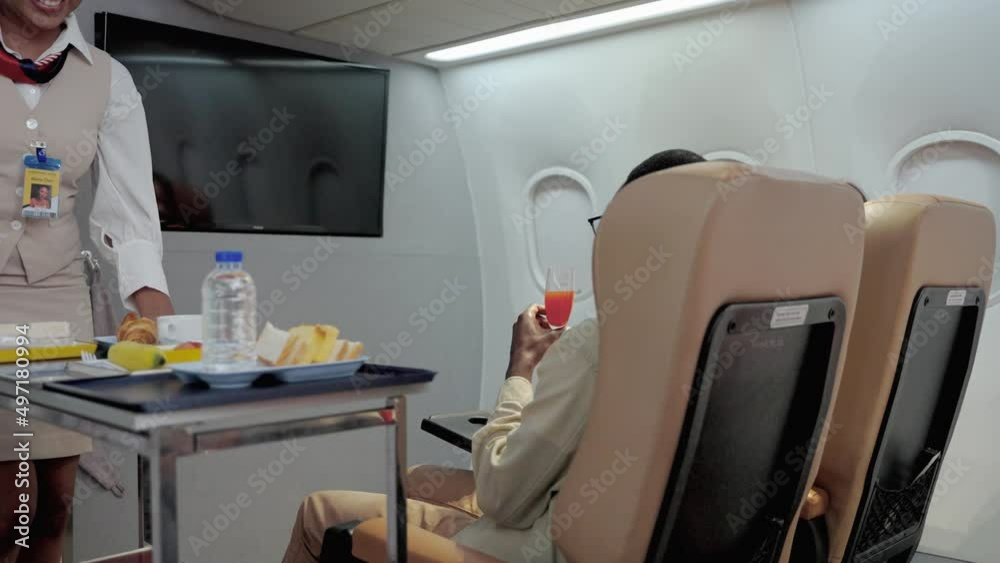 flight attendant is serving refreshments to business class passengers on board the plane.
flight attendant is serving refreshments to business class passengers on board the plane.