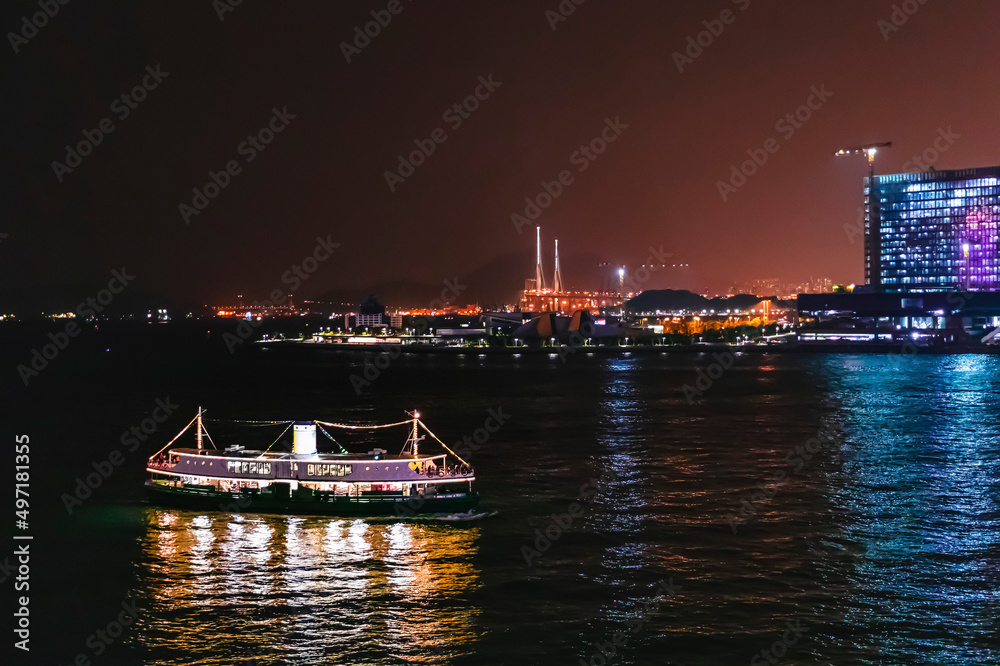 Naklejka premium Ferry passing victoria harbour at night, Hong Kong