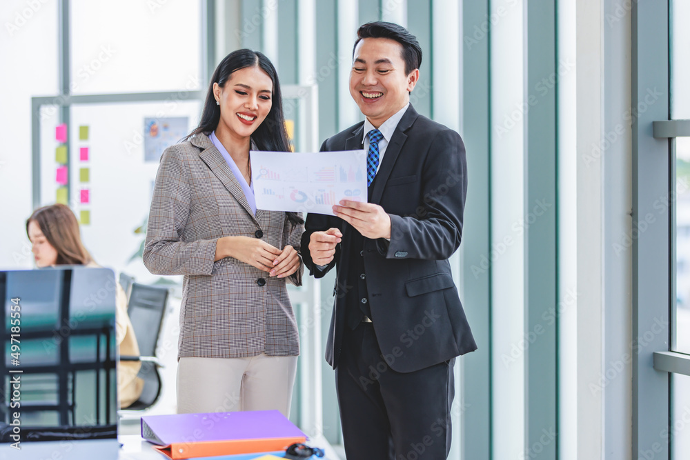 Millennial Asian professional successful male and female businessman businesswoman colleague in formal business suit standing holding report paperwork document discussing consulting for solution idea Millennial Asian professional successful male and female businessman businesswoman colleague in formal business suit standing holding report paperwork document discussing consulting for solution idea