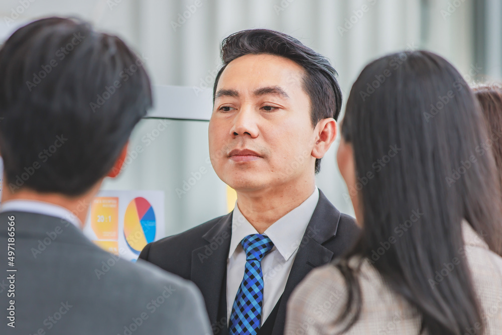 Asian happy male and female professional successful businessman and businesswoman colleagues partnership teamwork in formal business suit standing smiling look at post it note on glass board together Asian happy male and female professional successful businessman and businesswoman colleagues partnership teamwork in formal business suit standing smiling look at post it note on glass board together