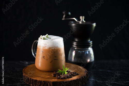Iced coffee cup with ice and coffee beans on old wooden floor