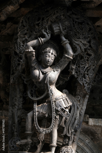 Stone Sculpture of Beautiful Female (Madanikas) with selective focus, 12th century Hindu temple, Ancient stone art and sculptures in each pillars, Chennakeshava Temple, Belur, Karnataka, India. photo