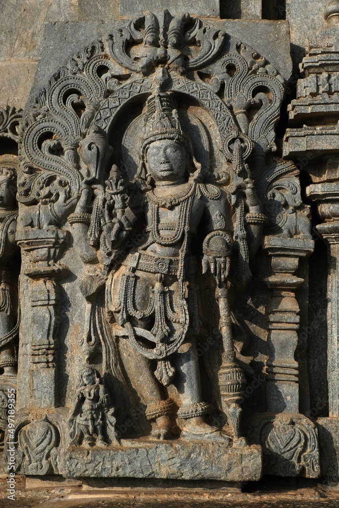 Fototapeta premium Stone Sculpture of Beautiful Female (Madanikas) with selective focus, 12th century Hindu temple, Ancient stone art and sculptures in each pillars, Chennakeshava Temple, Belur, Karnataka, India.