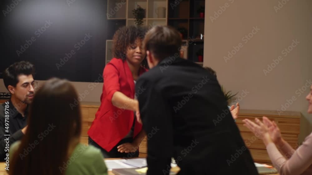 African-American businesswoman and Caucasian businessman shaking hands after signing contract, members of meeting clapping hands, to celebrating of achieving goals success in meeting room, slow motion African-American businesswoman and Caucasian businessman shaking hands after signing contract, members of meeting clapping hands, to celebrating of achieving goals success in meeting room, slow motion