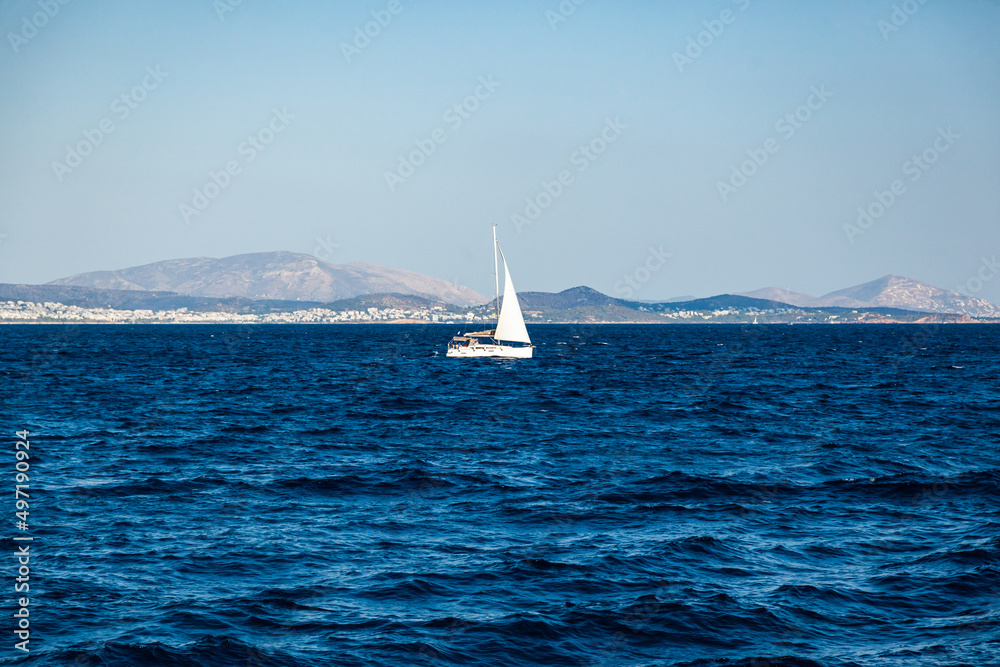 Sailing yachts in the sea bay against the backdrop of mountains off the coast of Greece.