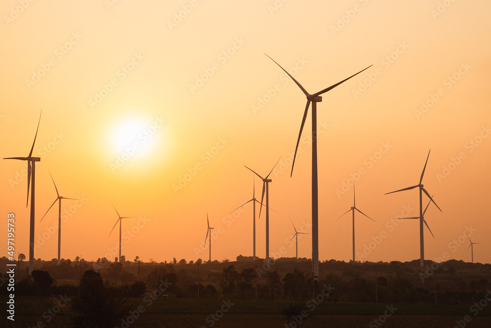 Windmills for electric power production, windmill farm or wind park with high wind turbines for generation electricity at sunset. Green energy concept. Windmills for electric power production, windmill farm or wind park with high wind turbines for generation electricity at sunset. Green energy concept.