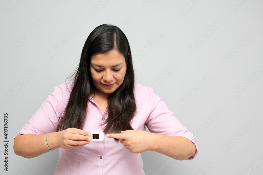 Latin adult woman with dark brown hair shows in her hand an oximeter on her finger that measures her oxygenation for suspicion of Covid-19 in the new normality due to the coronavirus pandemic
Latin adult woman with dark brown hair shows in her hand an oximeter on her finger that measures her oxygenation for suspicion of Covid-19 in the new normality due to the coronavirus pandemic