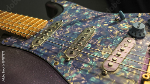 Purple electric guitar close-up. Detailed photo of an elegant electric guitar. Old-school guitar close-up. Pickups and accessories for electric guitars. Stratocaster.