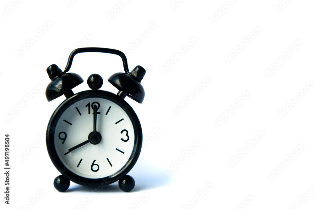 Black alarm clock isolated on white background. The clock set at 8 o'clock. Black alarm clock isolated on white background. The clock set at 8 o'clock.