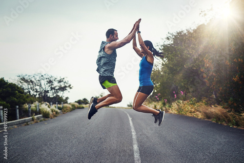 We did it and we did it together. Shot of a young attractive couple training for a marathon outdoors.