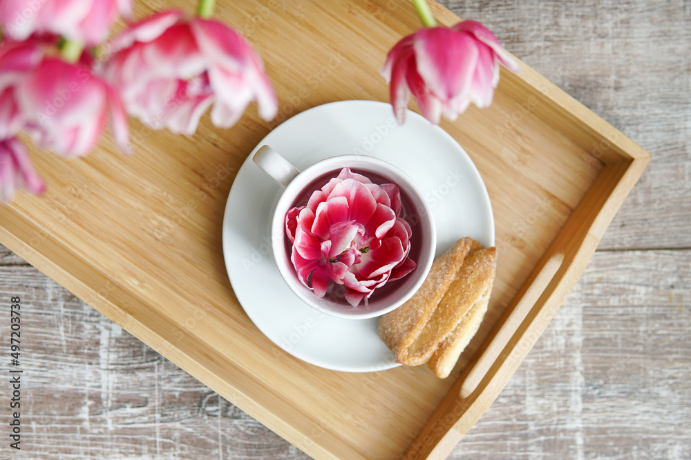 Fototapeta premium Breakfast with flowers. Cup on tray