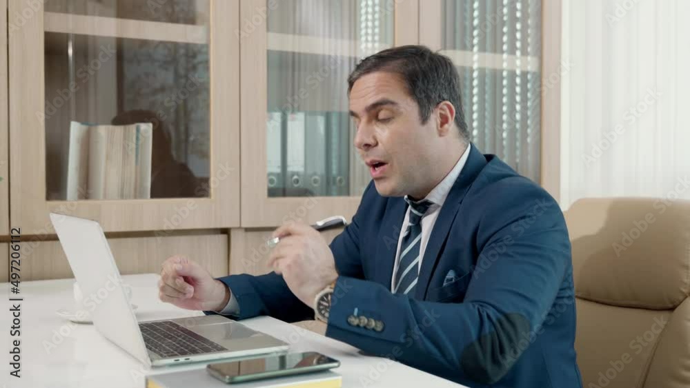 Business man sitting using laptop computer videoconferencing with colleagues on desk, happy man participating talking online video conference call virtual meeting remote working online in office Business man sitting using laptop computer videoconferencing with colleagues on desk, happy man participating talking online video conference call virtual meeting remote working online in office