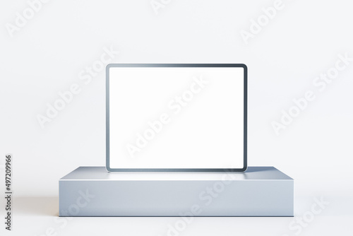 фотографія Close up of blank digital pad on round pedestal on white background with mock up place