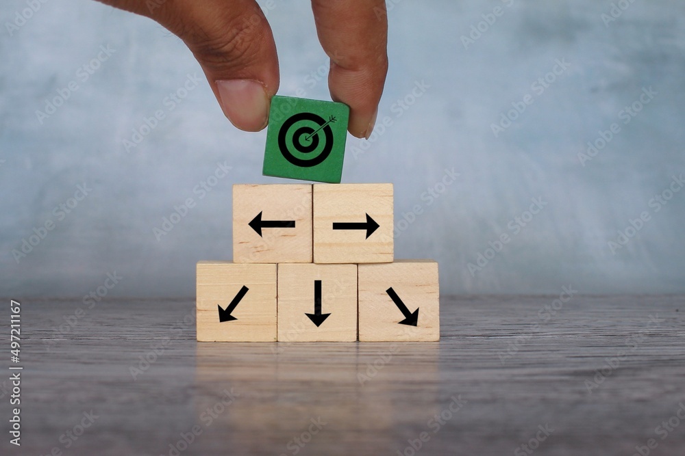 Wooden cubes with target icon and arrow pointing different direction. Organize a team, set a goal. Wooden cubes with target icon and arrow pointing different direction. Organize a team, set a goal.