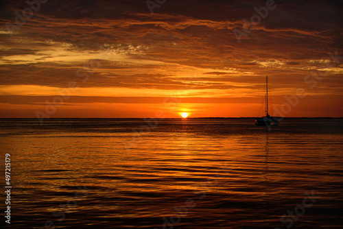 Golden sunset at the sea. landscape with sunset over the ocean, boat, sailboat. © Volodymyr