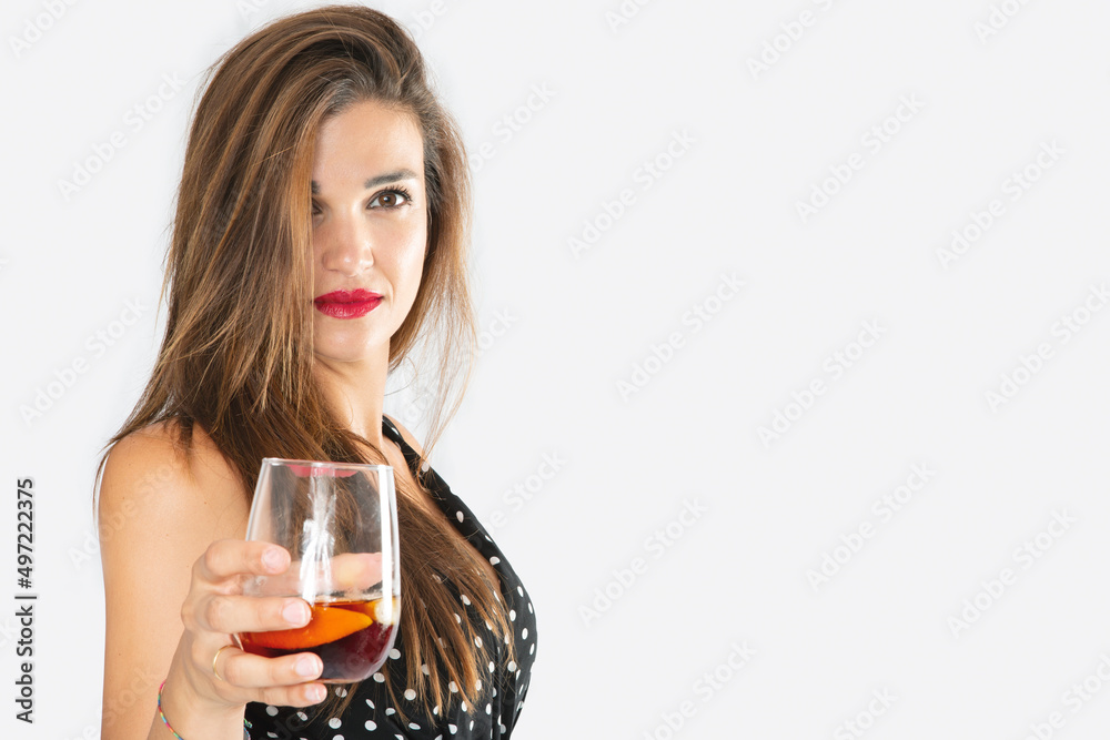 Pretty and elegant woman with a glass of liquor in her hand, directing her gaze and inviting a toast Pretty and elegant woman with a glass of liquor in her hand, directing her gaze and inviting a toast