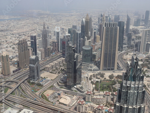 Dubai, UAE- March 31 2022: Daylight view of the skyline of a megacity with massive buildings and highways. Dubai Metropolis as seen from the Burj Khalifa.