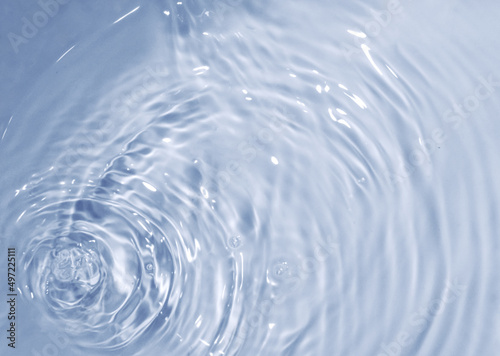 Circles on water. Blue round shadows. Blurred background made with water and light in monochrome. Pureness and freshness concept.