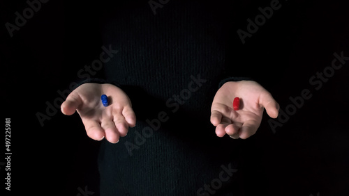 Red and blue pills on hands isolated on a black background
