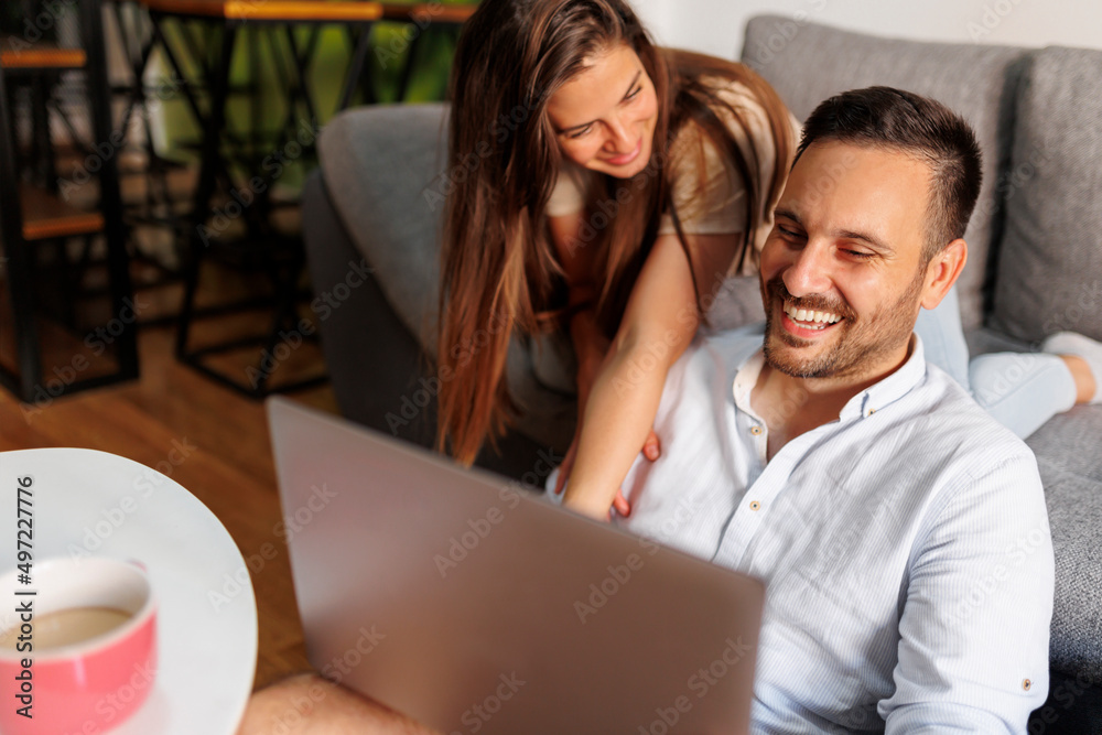 Couple having fun using laptop computer at home Couple having fun using laptop computer at home