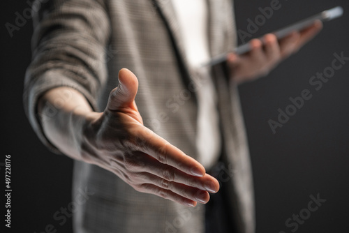 businessman holds out his hand for a handshake