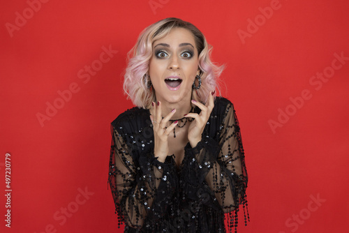 positive shock  emotion beauty woman in black dress on red background