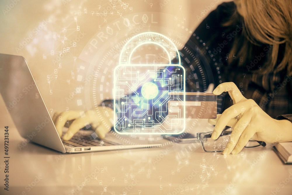 Double exposure of woman on-line shopping holding a credit card and Lock hologram drawing. Security E-commerce concept. Double exposure of woman on-line shopping holding a credit card and Lock hologram drawing. Security E-commerce concept.